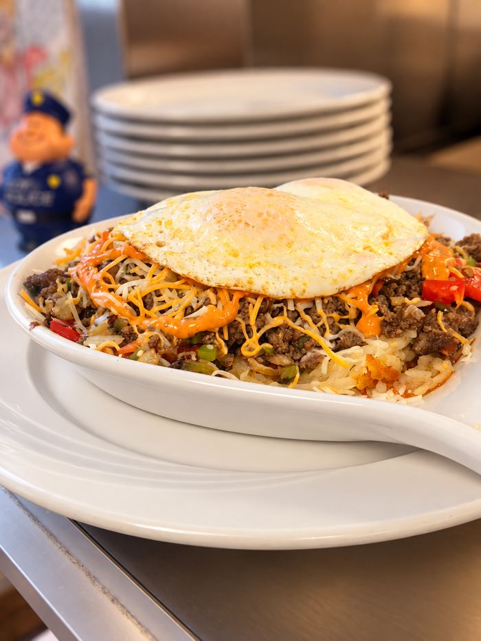 Mexican Skillet: seasoned ground beef, peppers, onion and melted cheese with chipotle sauce, topped with a fried egg over hash browns