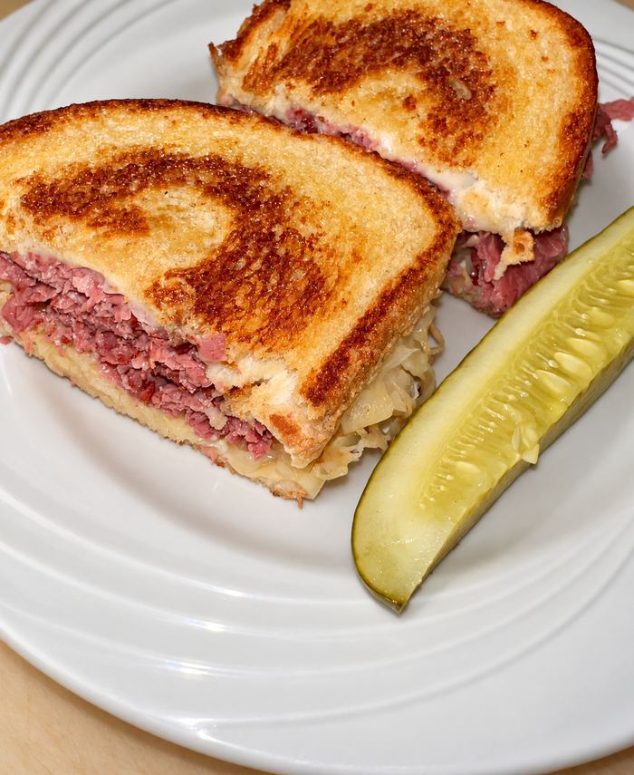 Reuben on grilled rye with corned beef, sauerkraut and swiss, with a pickle spear
