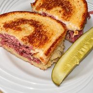Reuben on grilled rye with corned beef, sauerkraut and swiss, with a pickle spear